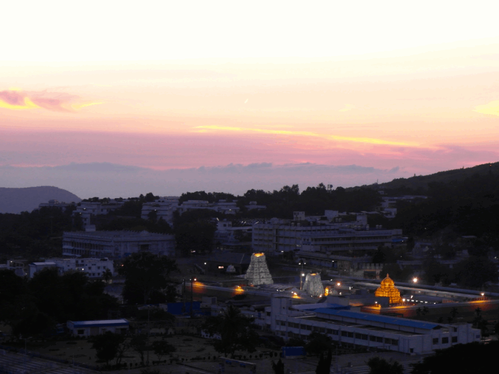 Cityscape at dusk with illuminated buildings and a colorful sky.