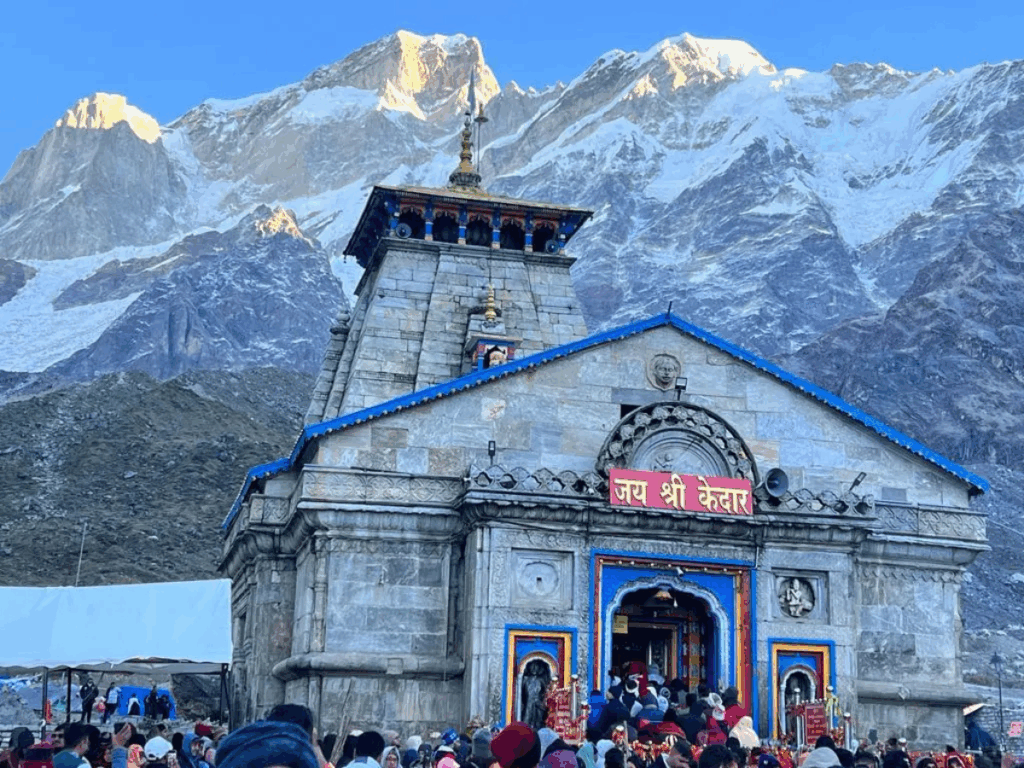 Ancient temple nestled in snowy Himalayan mountains under clear blue sky.